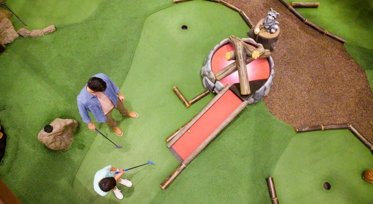 A father and son plays a round of mini golf at Great Wolf Resorts
