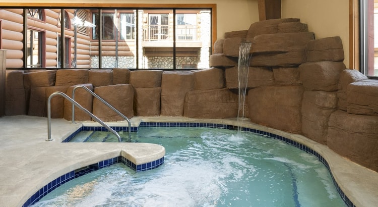 A family of four relaxes in the indoor pool