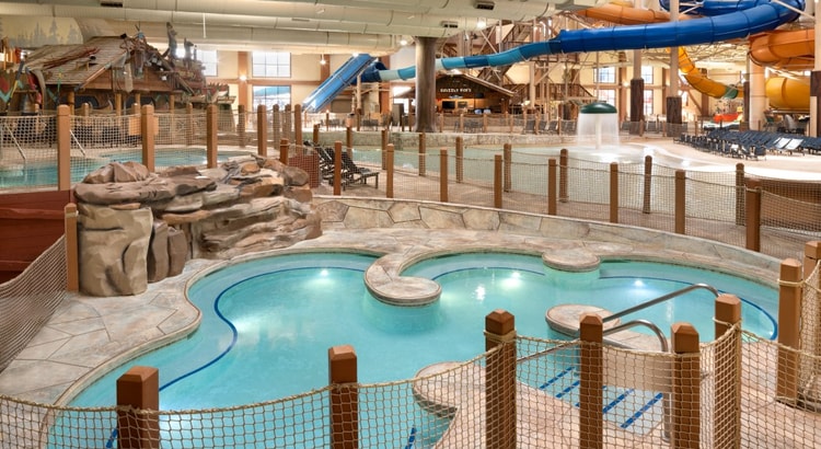 A family of four relaxes in the indoor pool