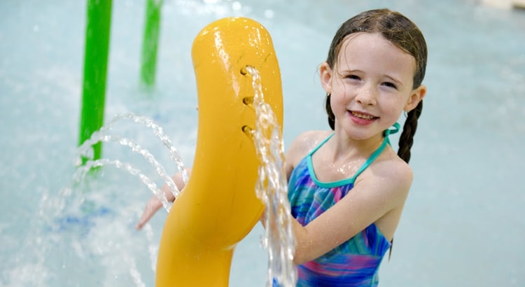 Kids play behind the outdoor water features 