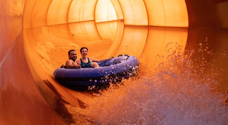 A family enjoys rafting together at Great Wolf Lodge indoor water park and resort.