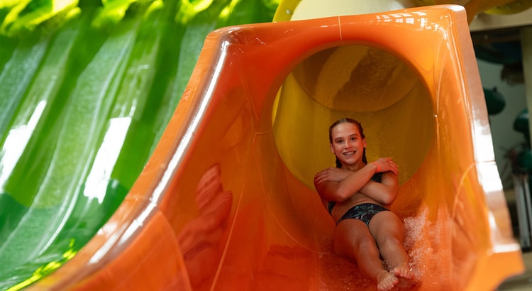 a girl coming down a yellow slide