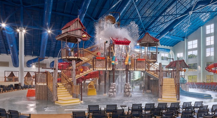 A wide shot of the  water treehouse as water splashes down from a bucket above the jungle gym