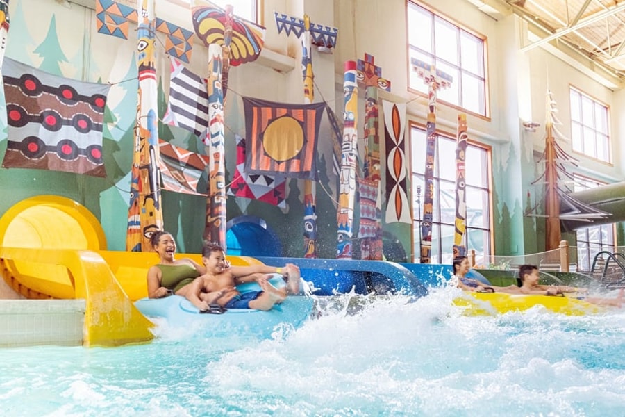 Family enjoying Bobcat Falls at Great Wolf Lodge indoor water park and resort.
