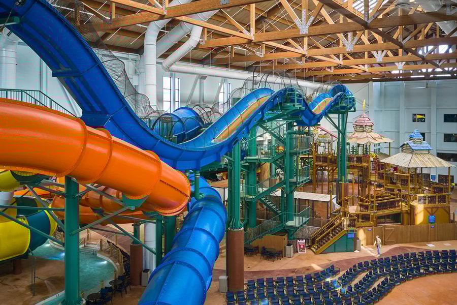 view of the indoor water park with a yellow and blue slide