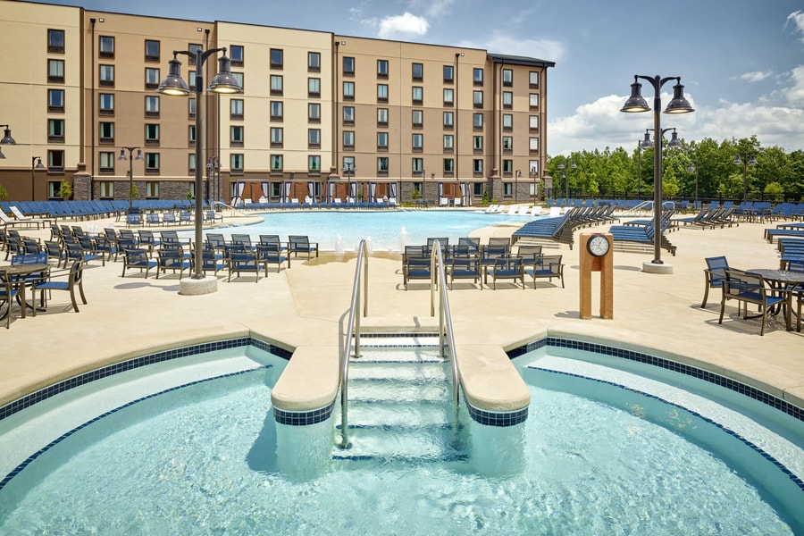 outdoor hot tub with a swimming pool in the background