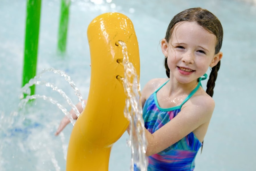 Kids play behind the outdoor water features 
