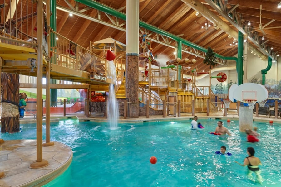 family playing basketball in indoor pool 