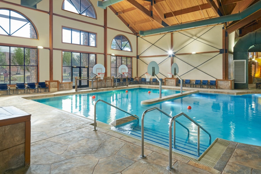 family playing basketball in indoor pool 