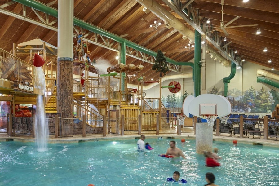 family playing basketball in indoor pool