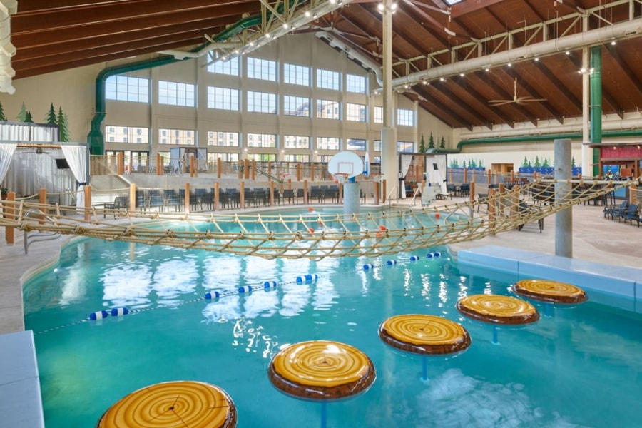 family playing basketball in indoor pool 