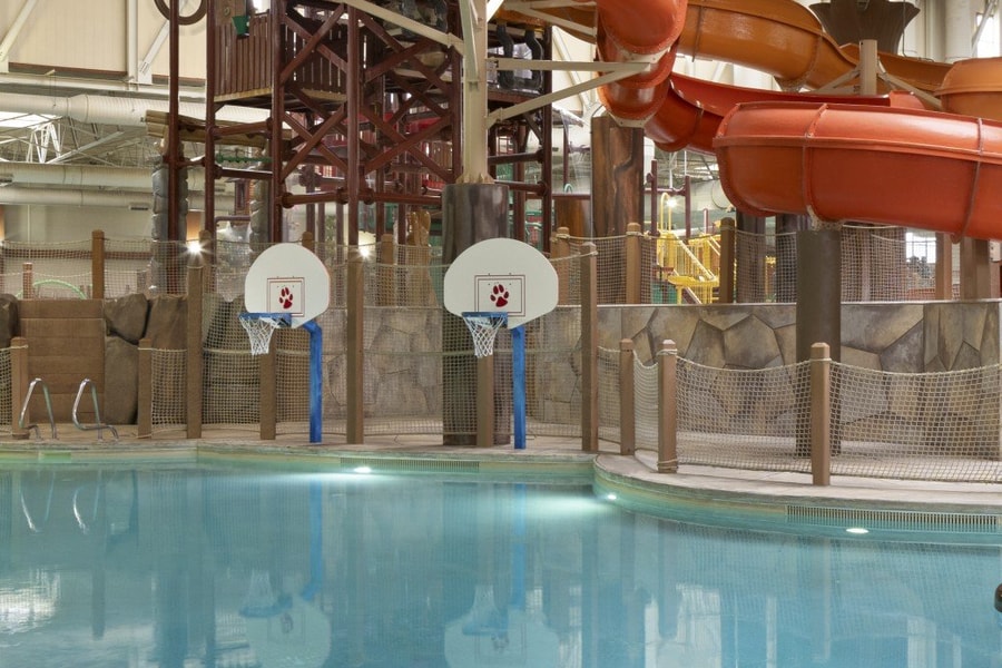 family playing basketball in indoor pool