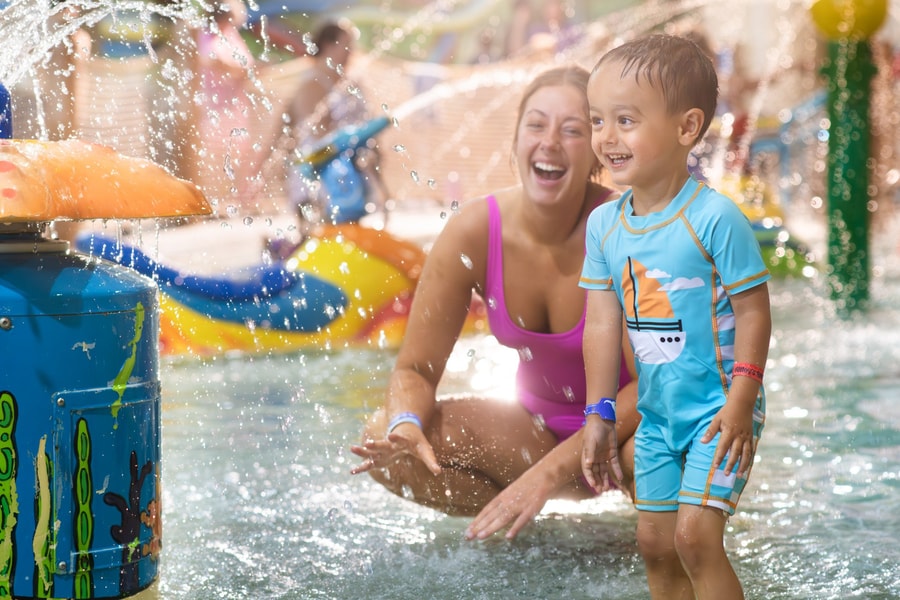 mother and child playing in a kiddie pool
