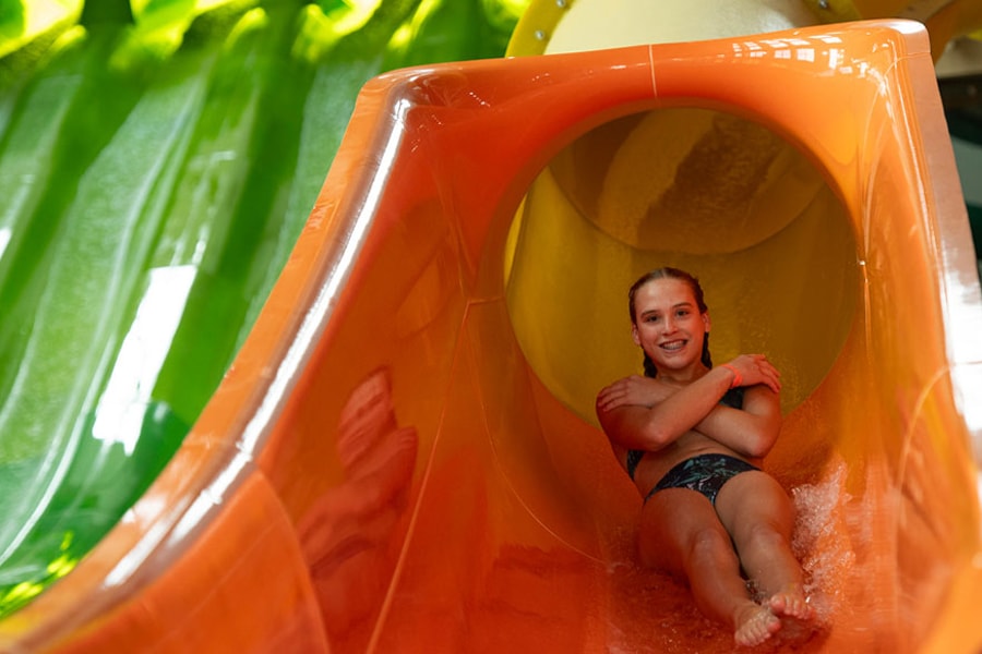 a girl coming down a yellow slide