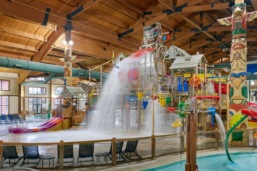 A wide shot of the  water treehouse as water splashes down from a bucket above the jungle gym