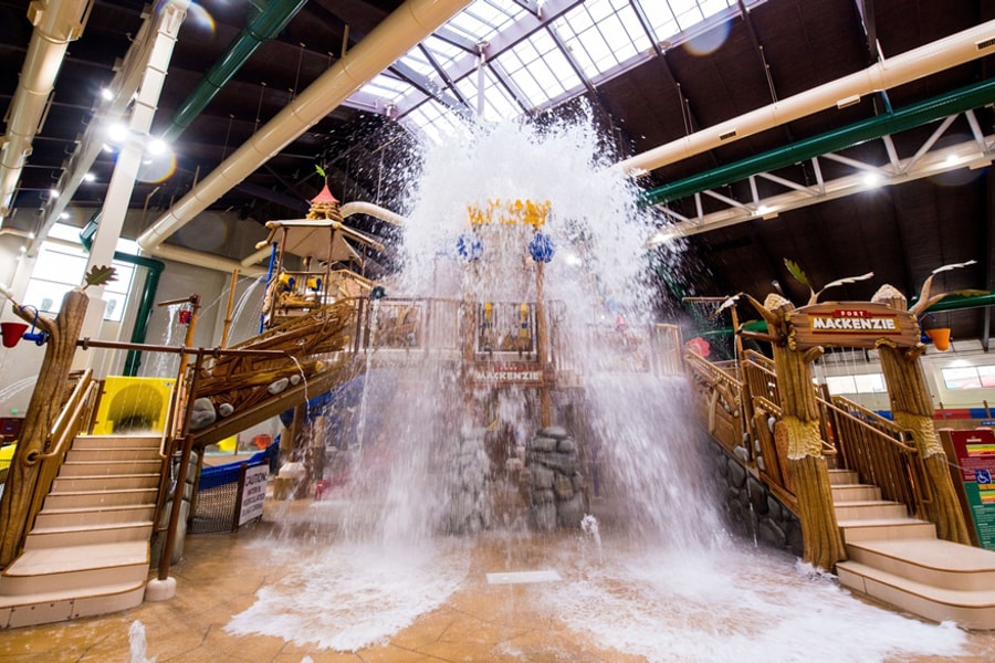 A wide shot of the  water treehouse as water splashes down from a bucket above the jungle gym