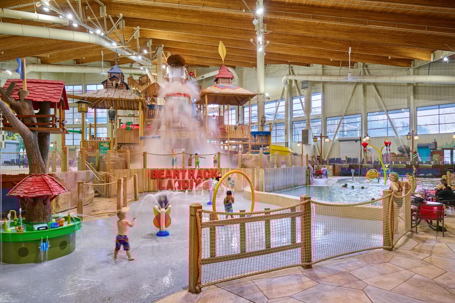 A wide shot of the  water treehouse as water splashes down from a bucket above the jungle gym