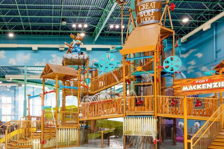 A wide shot of the  water treehouse as water splashes down from a bucket above the jungle gym