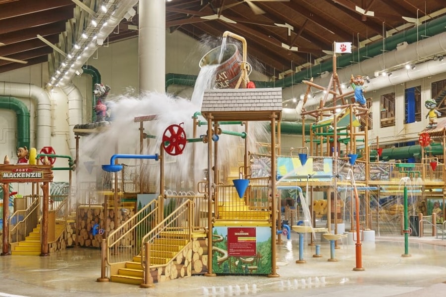 A wide shot of the  water treehouse as water splashes down from a bucket above the jungle gym