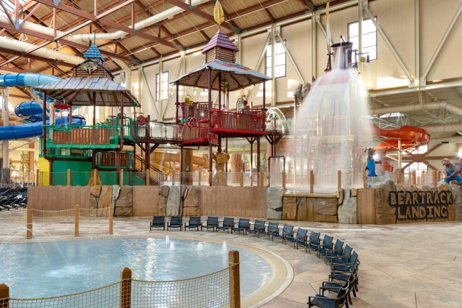 A wide shot of the  water treehouse as water splashes down from a bucket above the jungle gym