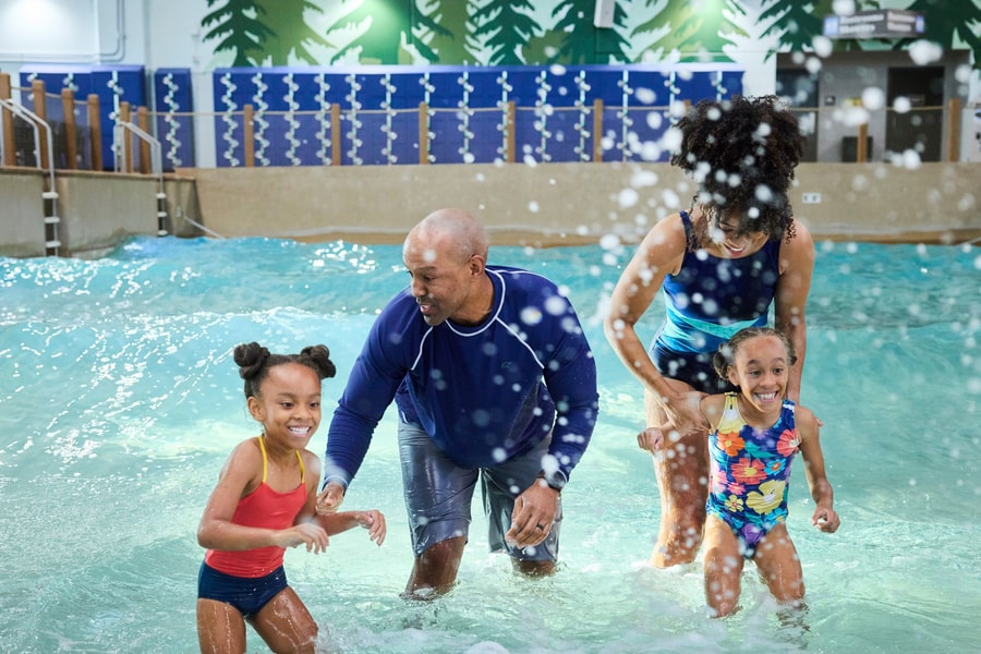 Family of four splashing water in a wave pool