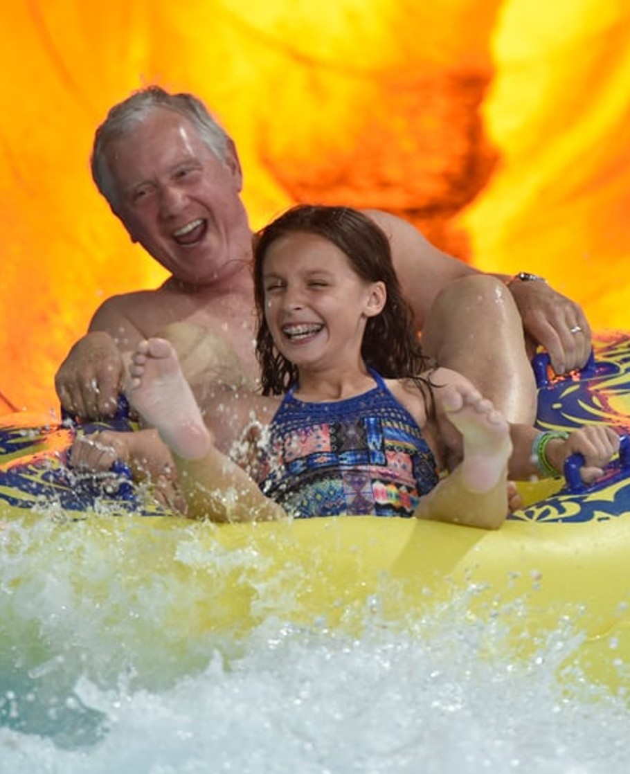 grandfather and granddaughter on a slide