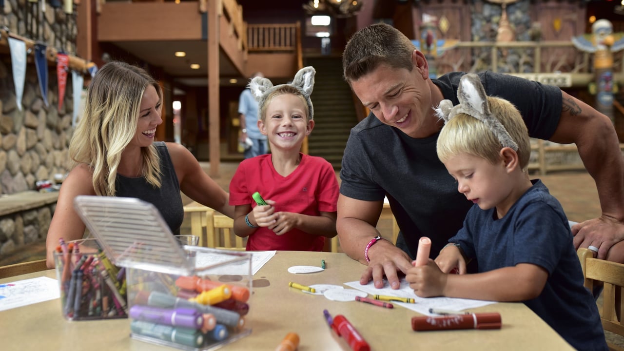 Family wearing wolf ears doing crafts at lodge table