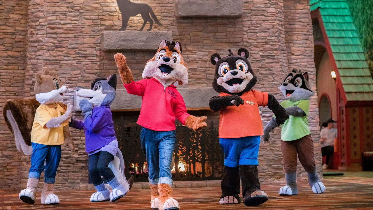 Five animal mascots dancing in a theme park setting