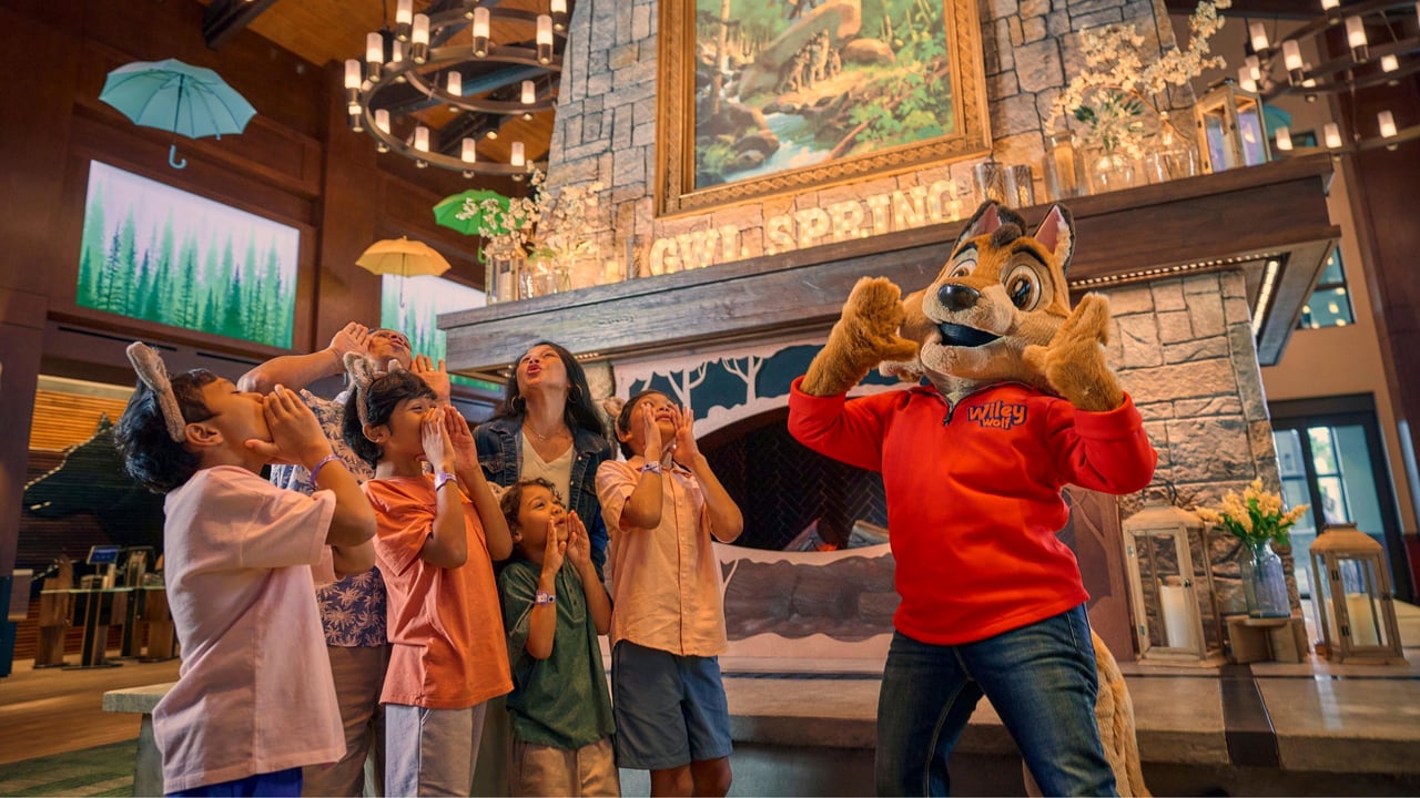 A mascot and kids posing in front of a fireplace