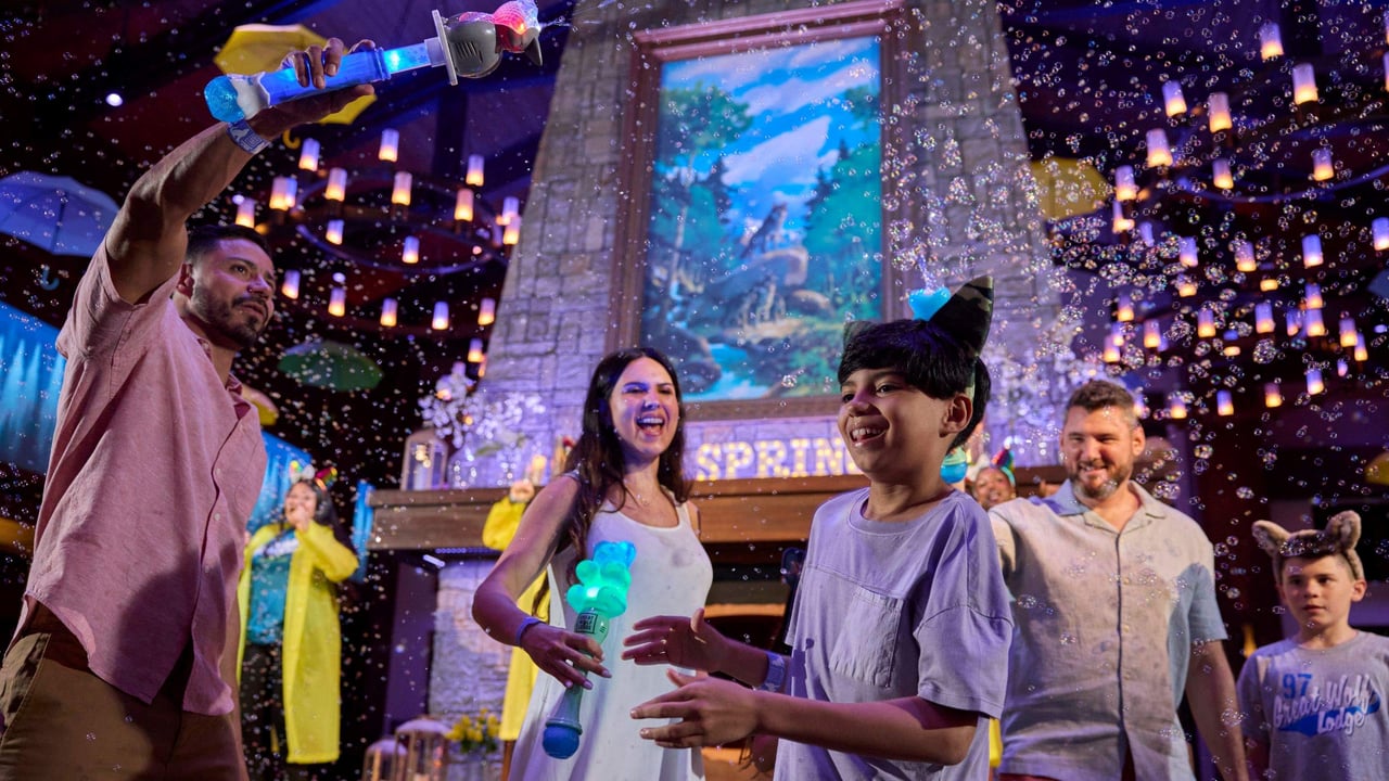 A family playing with bubbles in a lively, colorful party setup