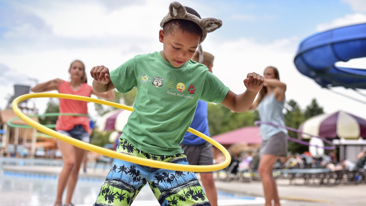Child hula hooping at a pool activity