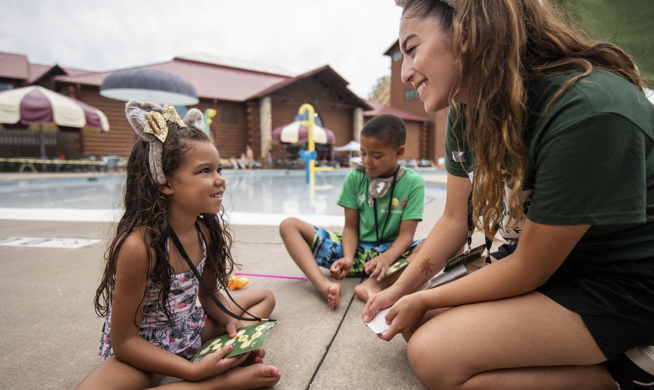 Child and staff member playing poolside game