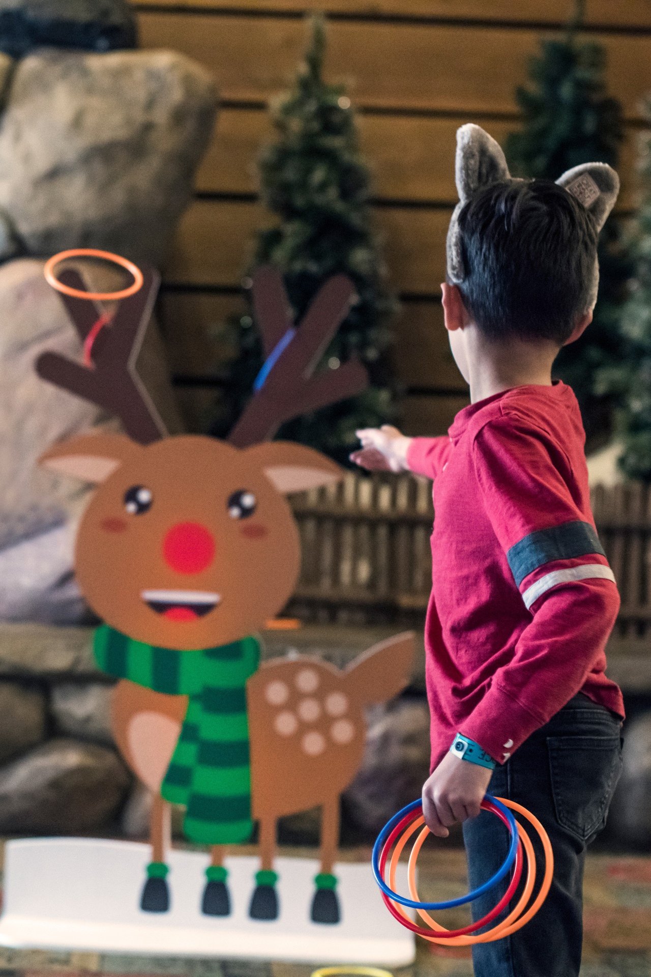 Child playing ring toss with reindeer