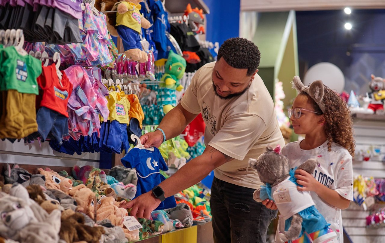 Father and daughter looking at stuffed toys