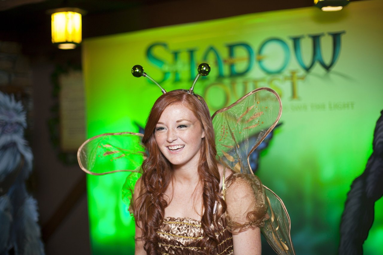 A young woman dressed as the Shadow Quest fairy, wearing wings and antennae 