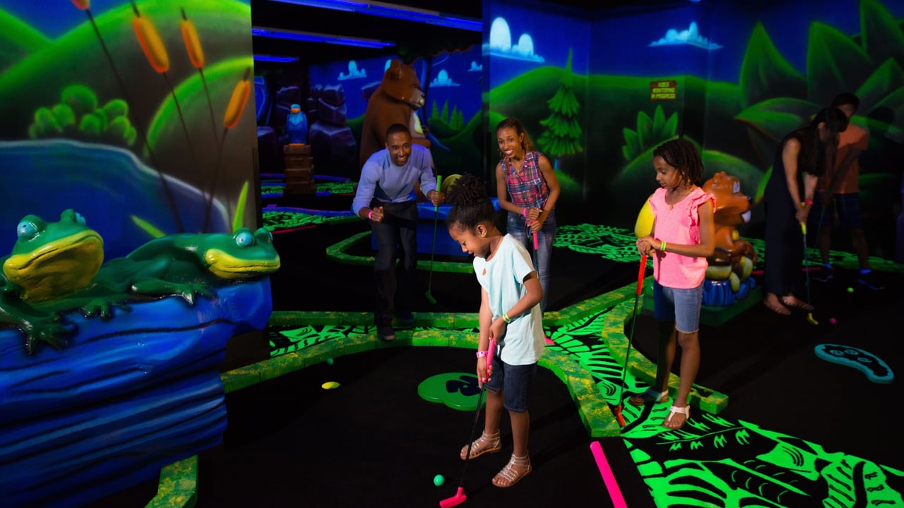 Family looking on as son putts