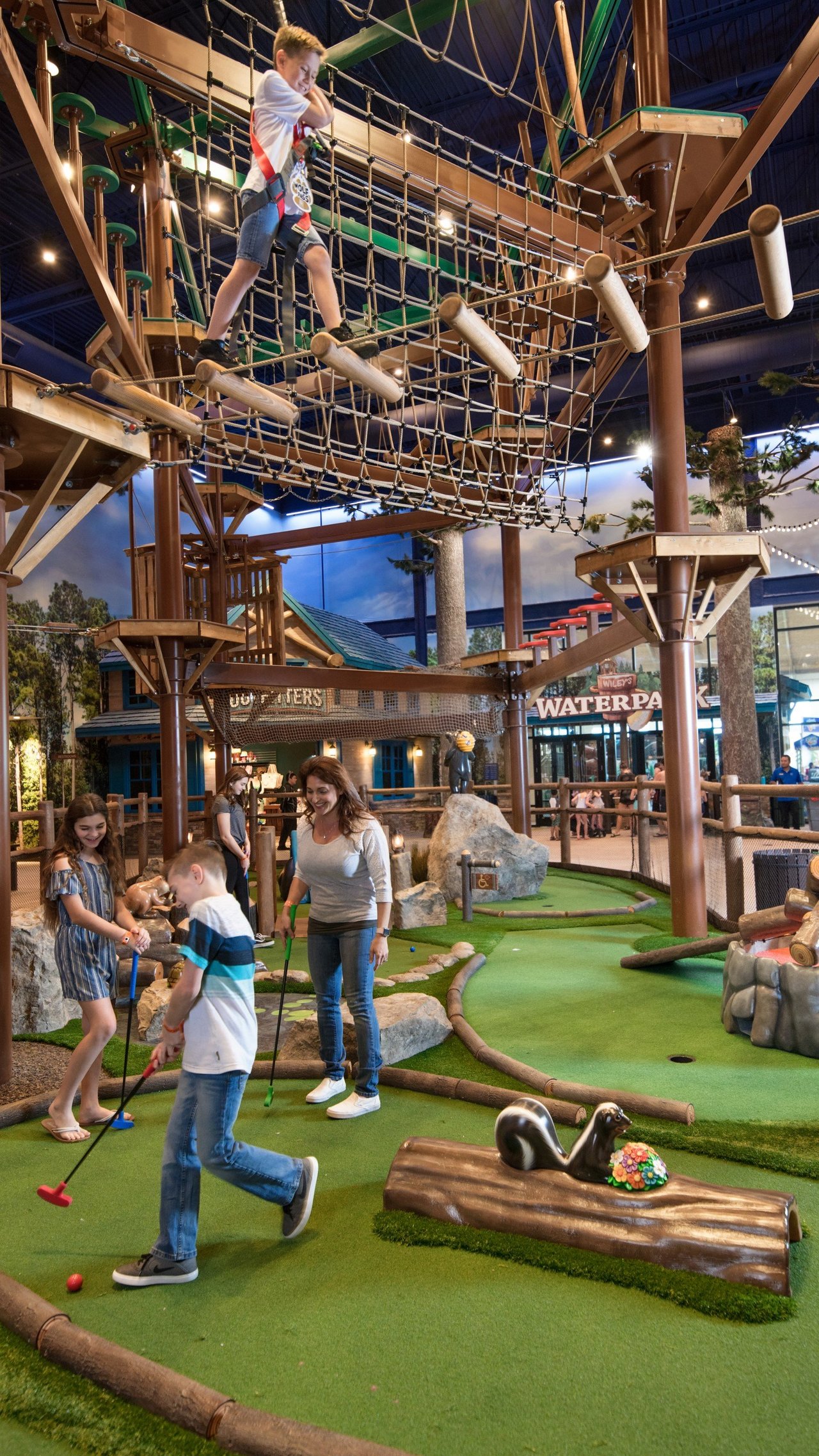 Mother is playing golf with her children