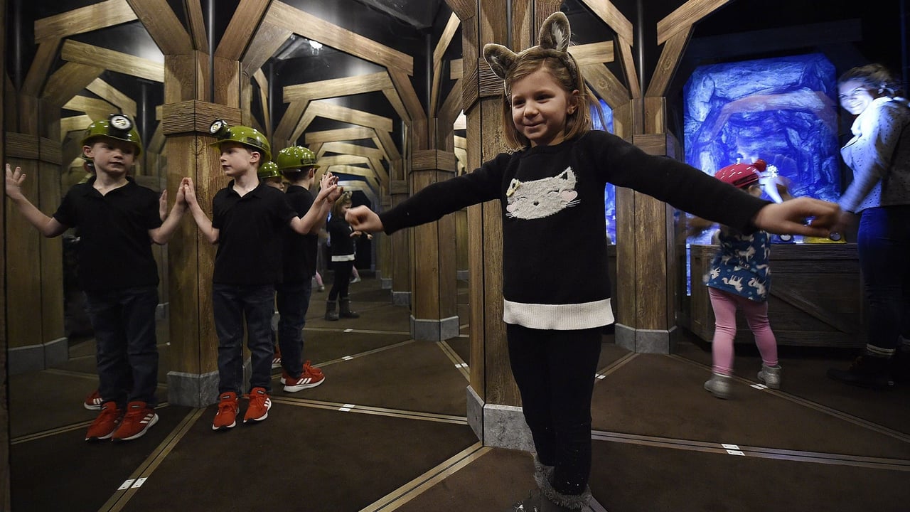 Children exploring a mirror maze with mining helmets