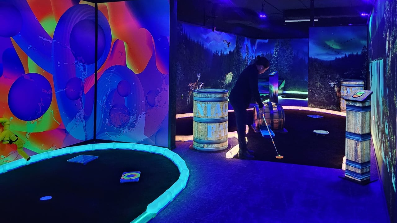 Person playing glow-in-the-dark mini golf