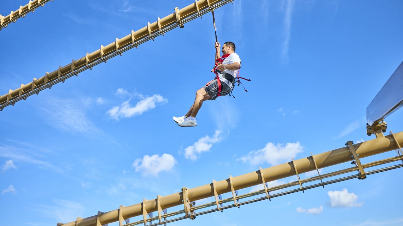 Man in harness gliding on high rope