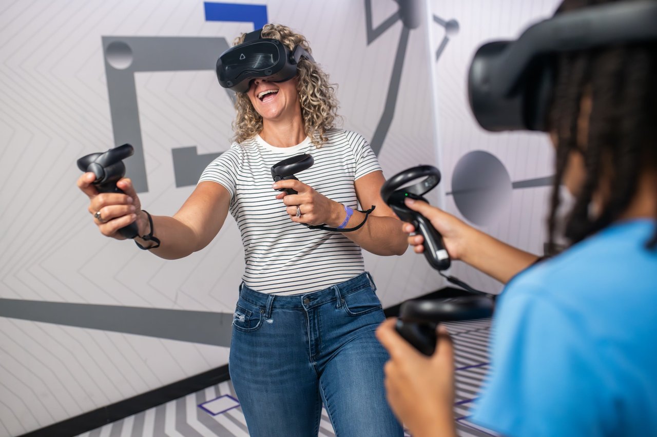 Smiling woman plays VR game with controllers