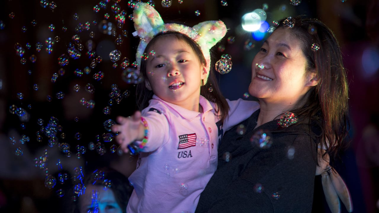 Little girl playing with bubbles in a party setup