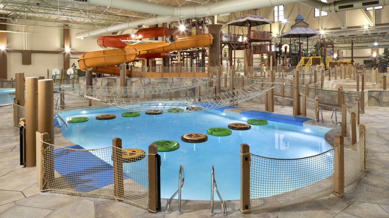 A vibrant indoor water park featuring multiple slides and pools