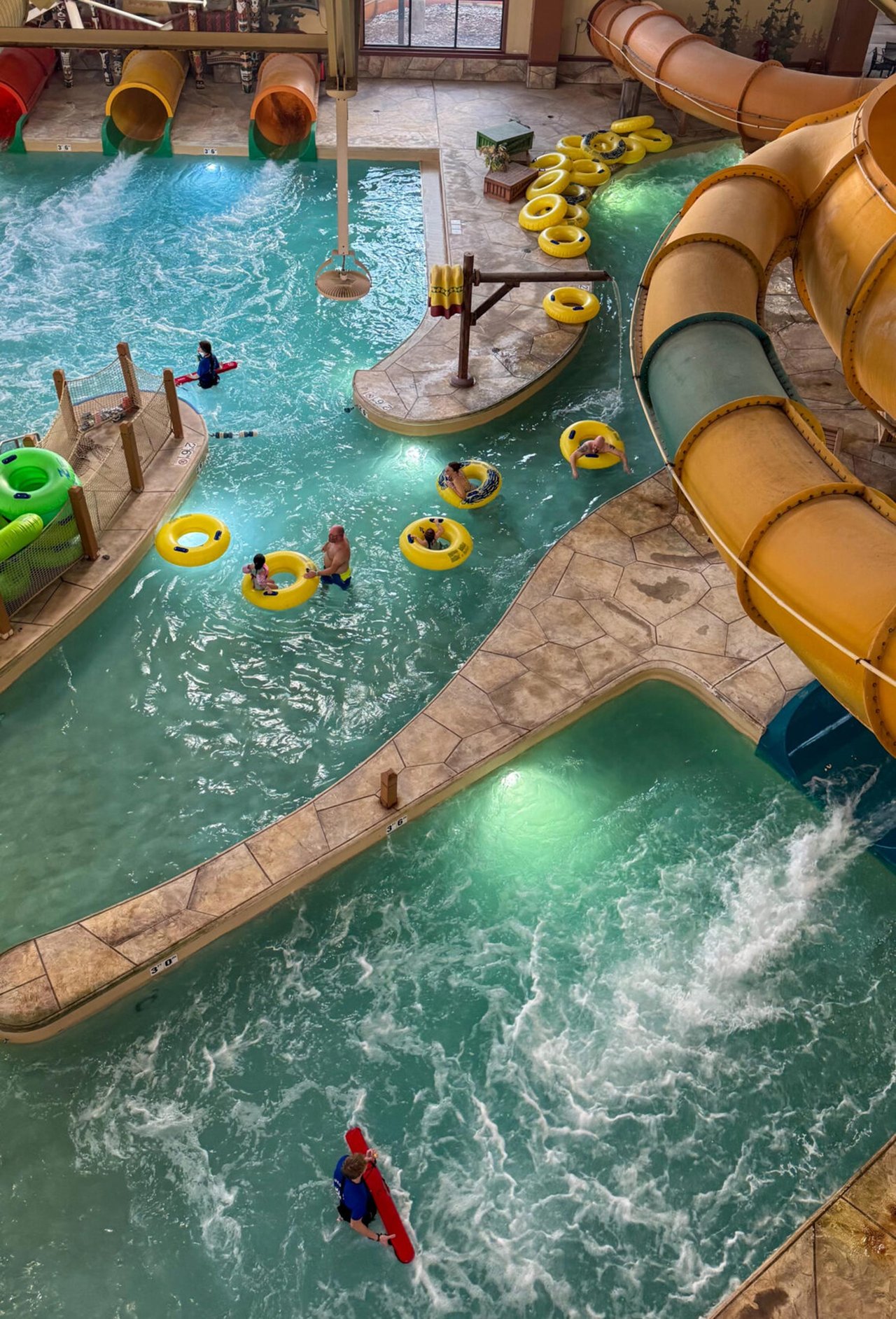 An aerial view of the pool below the water slide showing people floating on inner tubes.