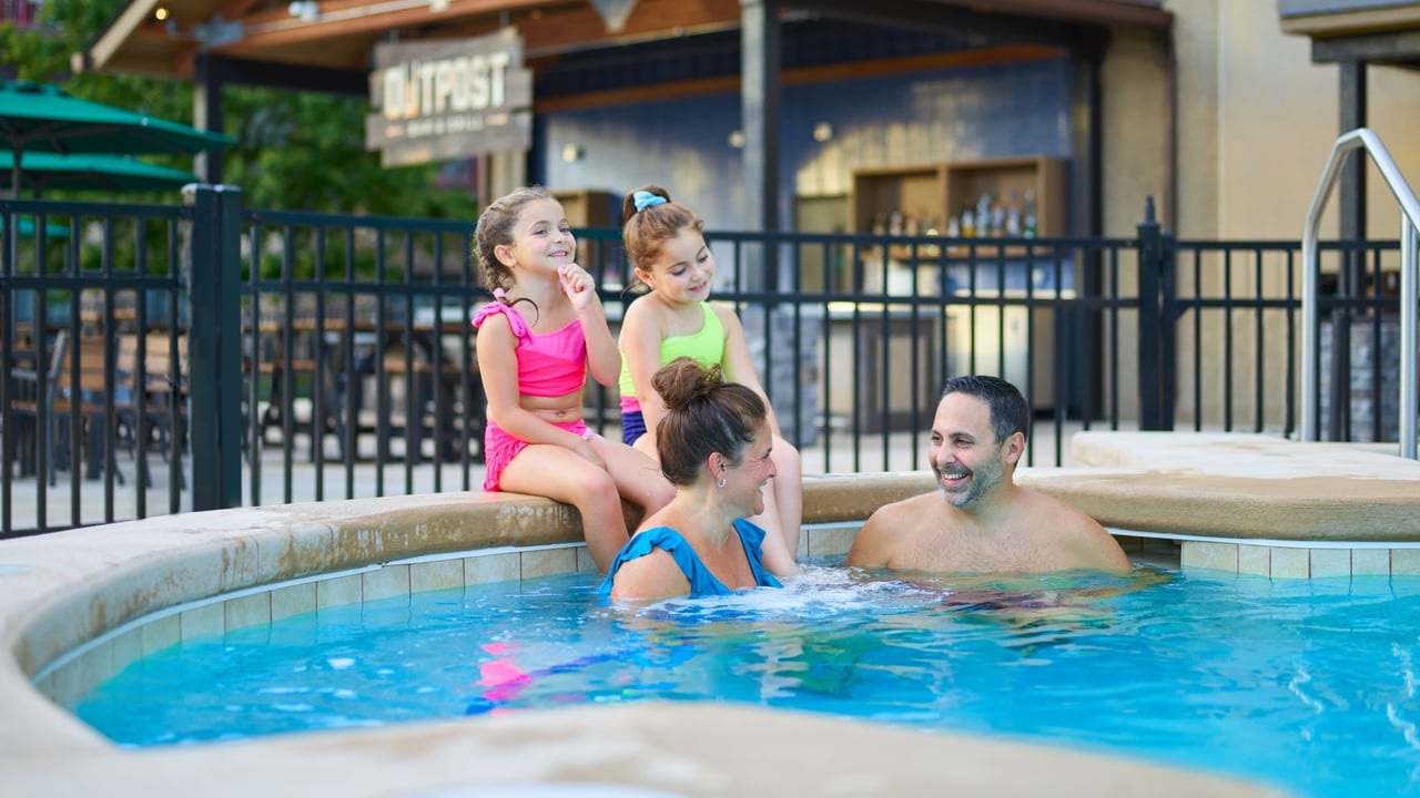 a family relaxes in an outdoor hot tub