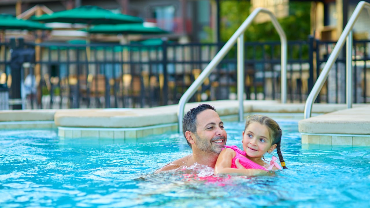 father holding his child in an outdoor hot tub