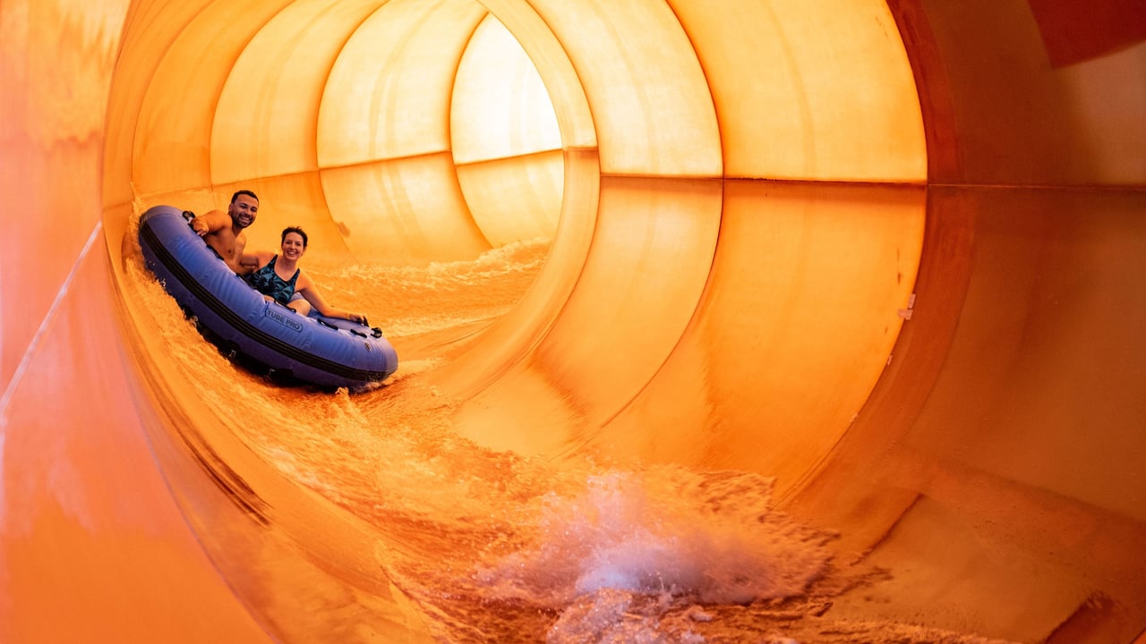 Couple on a blue raft going down a water slide