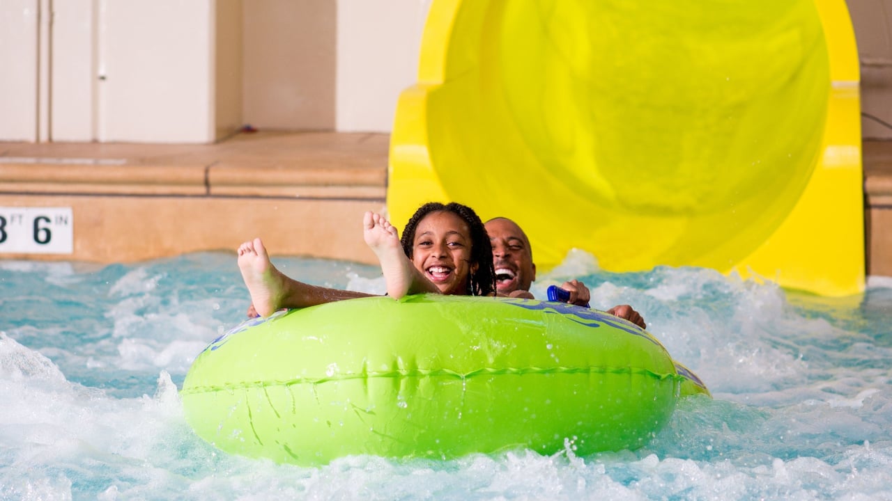 Mother and son on a green water slide tube
