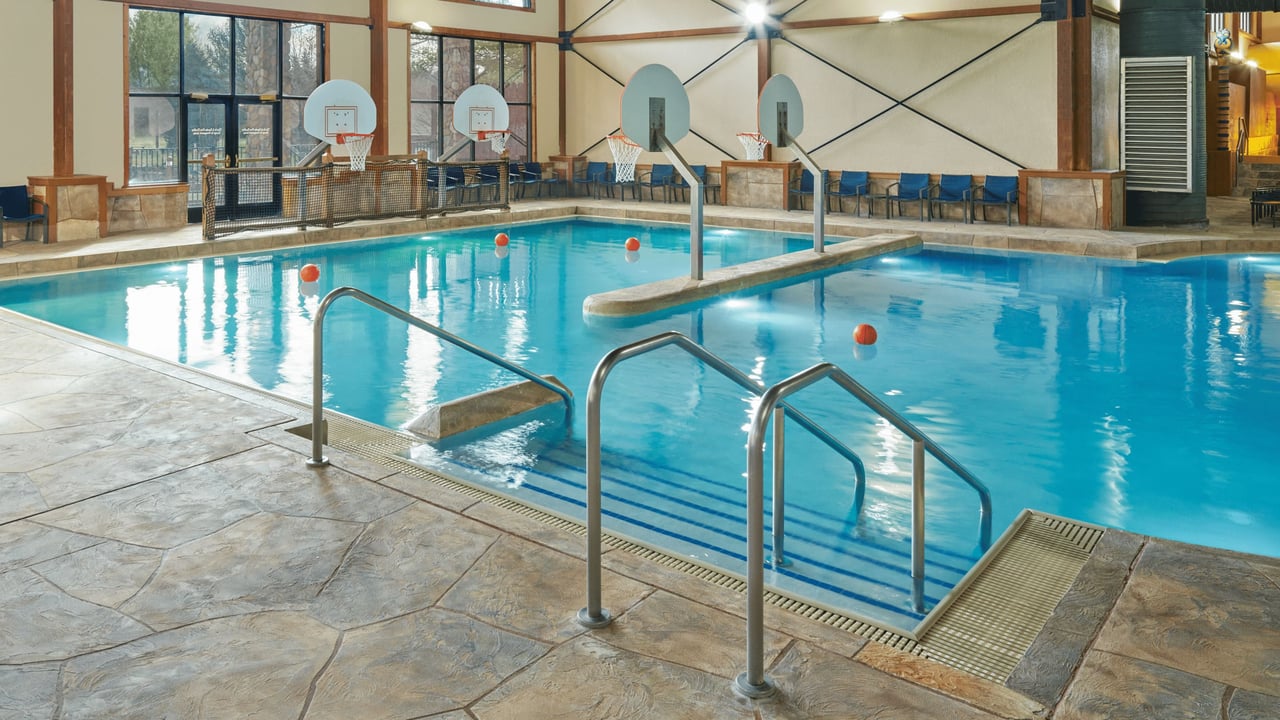  A spacious indoor pool featuring a large slide and multiple water slides for recreational enjoyment.