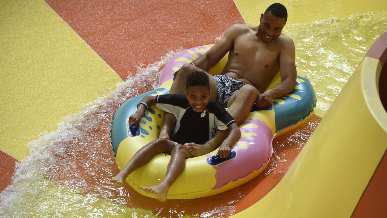 father and son on a double tube water slide